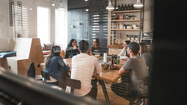 Group of people discussing carpet cleaning methods in a modern office setting.