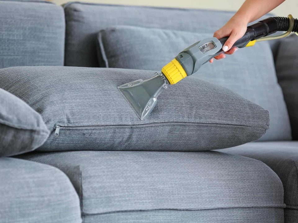 Sofa cleaning service in Singapore using upholstery extraction machine in a modern living room