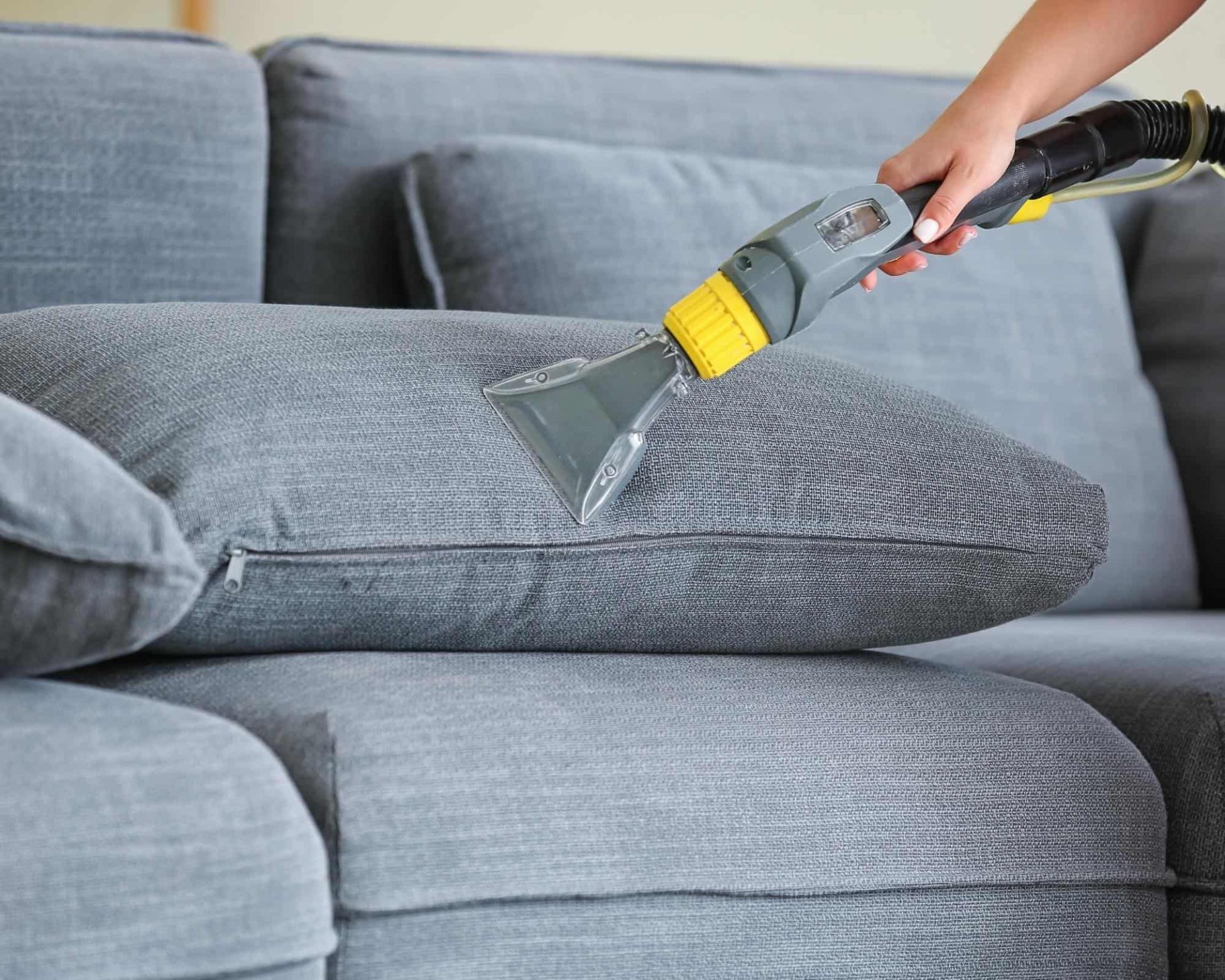 Sofa cleaning service in Singapore using upholstery extraction machine in a modern living room